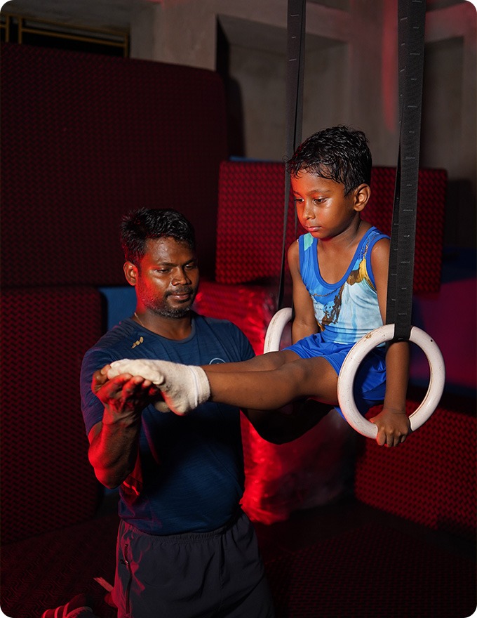 Gymnast on rings with coach